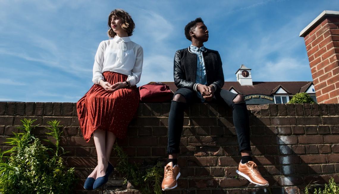 Still of short film Baby Gravy. Two young women sit on top of a wall