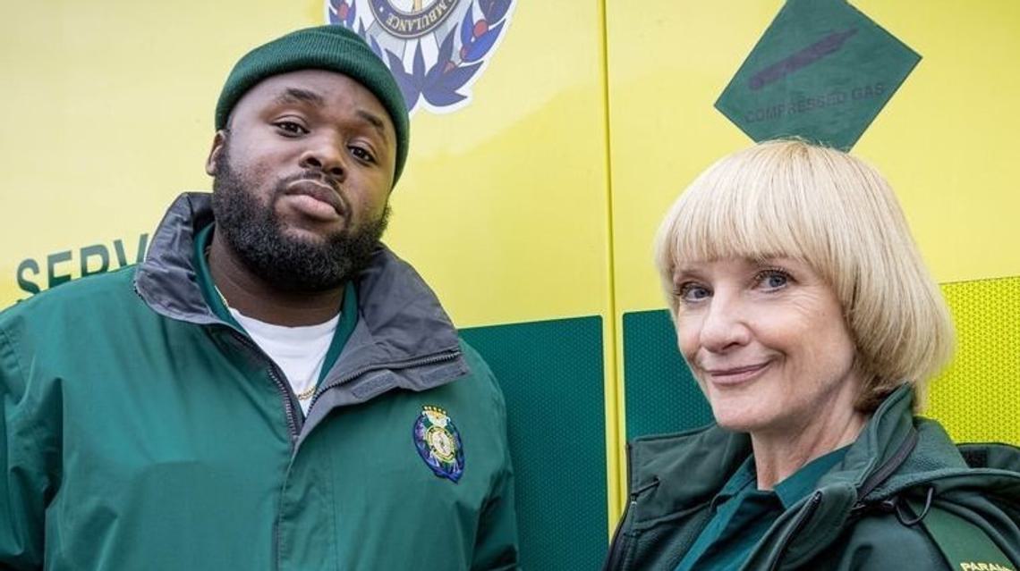 Still of Bloods. A man and woman looking directly into the camera in uniforms