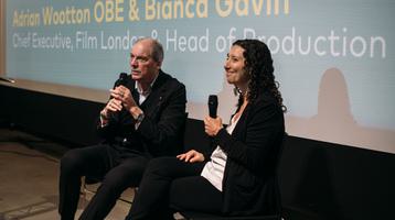 Adrian and Bianca sat on stage speaking