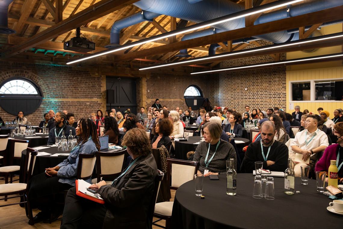 Crowded room, delegates sat around tables