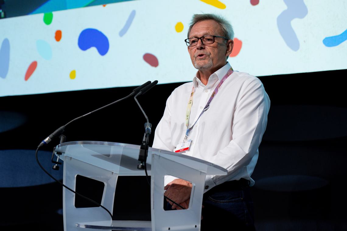 Julian Scott standing at lectern speaking at Cartoon Forum