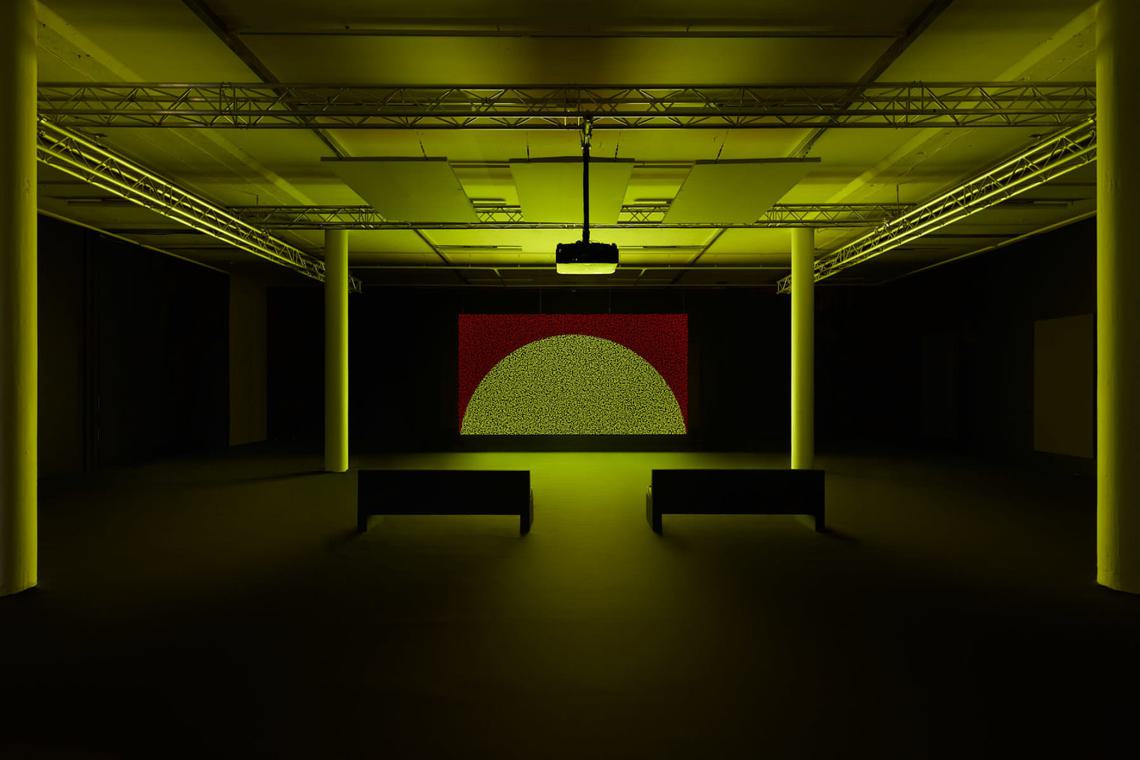 Two benches facing an image of a yellow semi-circle on a red background.