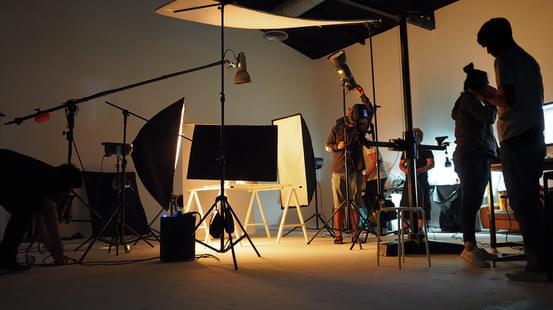 image of a film studio with people operating cameras and lights